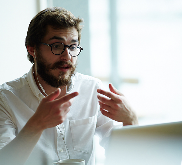 Man sitting in front of laptop, talking and gesticulating