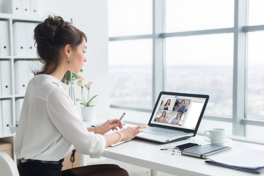 Woman sits in front of laptop and is in a video conference.