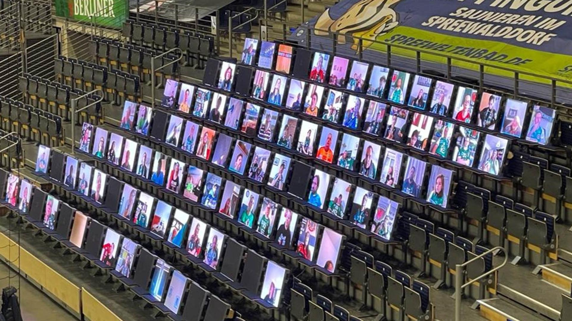Film showing the installation of many LED screens in the stands of a stadium. Video images of spectators are broadcast live on the displays. Text overlays in the film: GDPR-compliant and made in Germany. Digitise your event. 500 or more people connected audiovisually at the same time. Live in the stadium with alfaview. In the highest quality and stability.